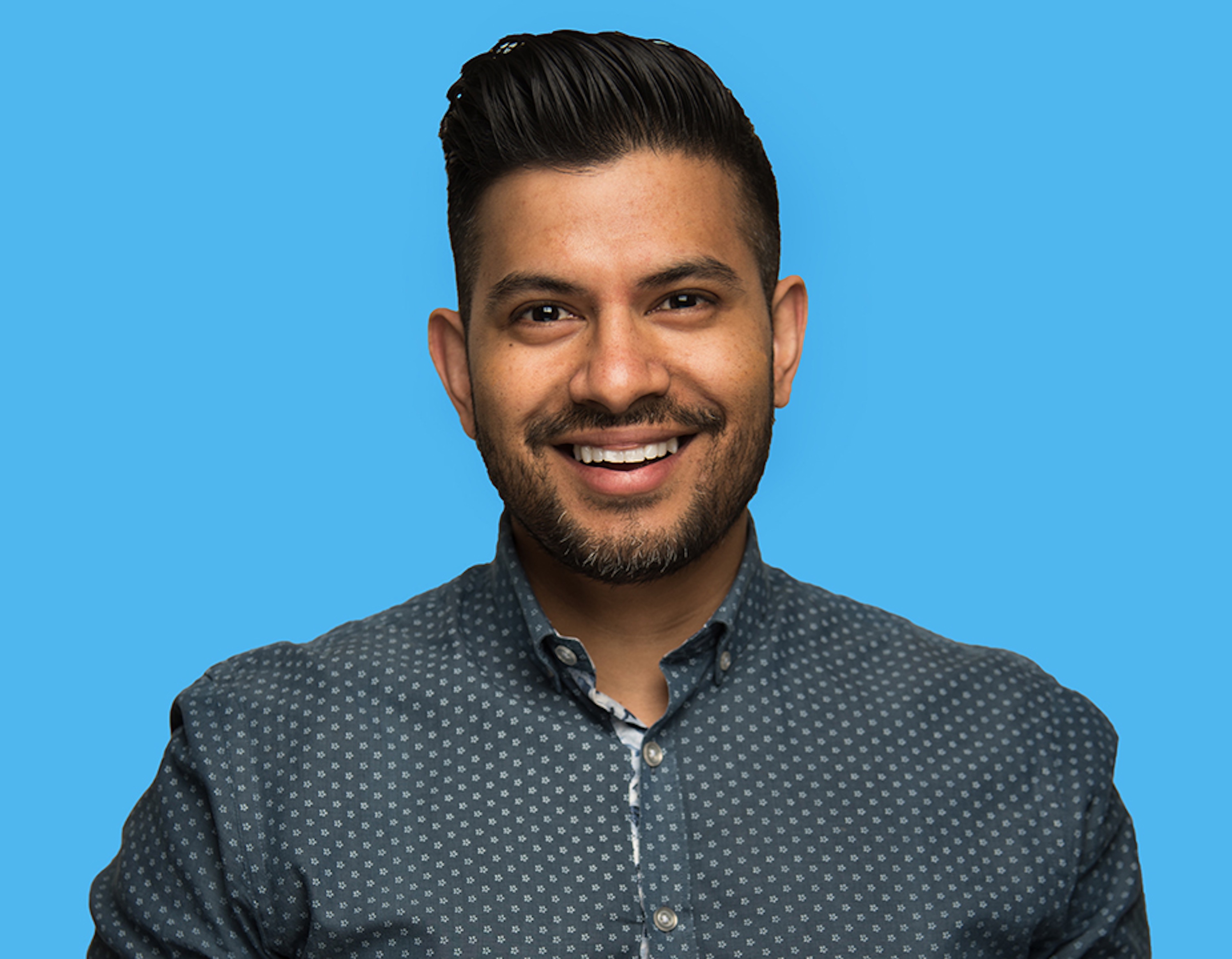 A picture of a man smiling in a polka-dot button down shirt A picture of a man smiling in a polka-dot button down shirt